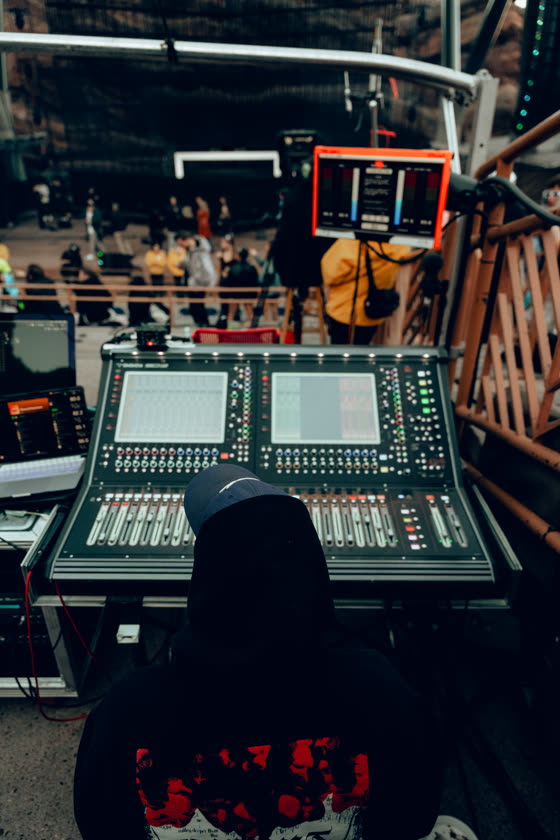 Audio engineer running a live mix from the front-of-house console