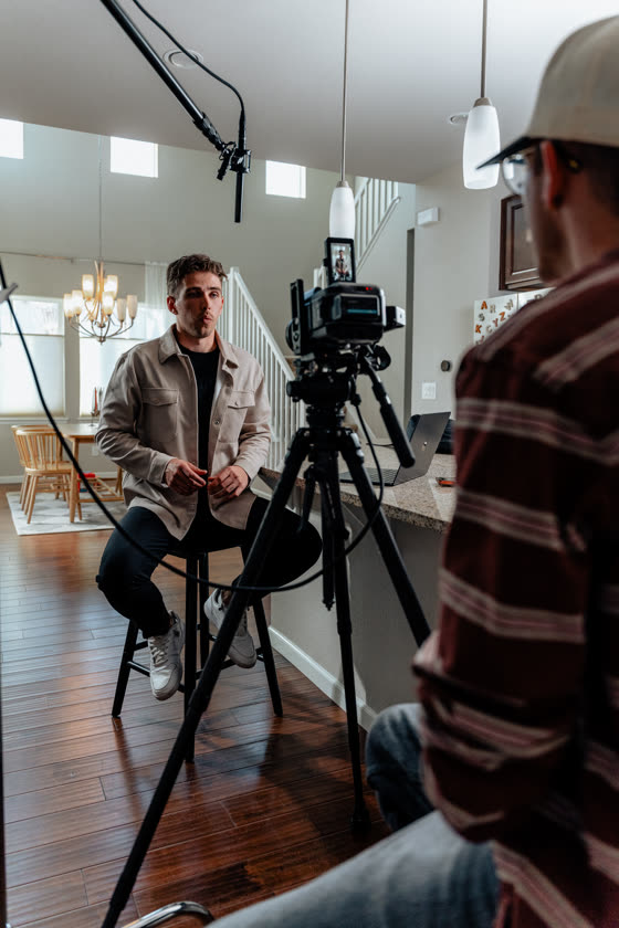 Business owner mid-interview under lights during an on-location shoot