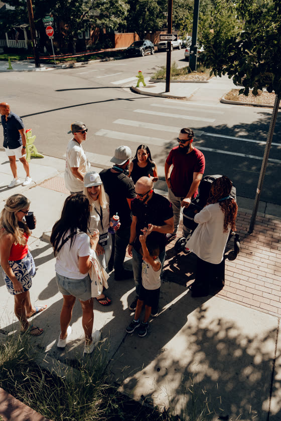 Crowd gathering on the sidewalk at a neighborhood street event