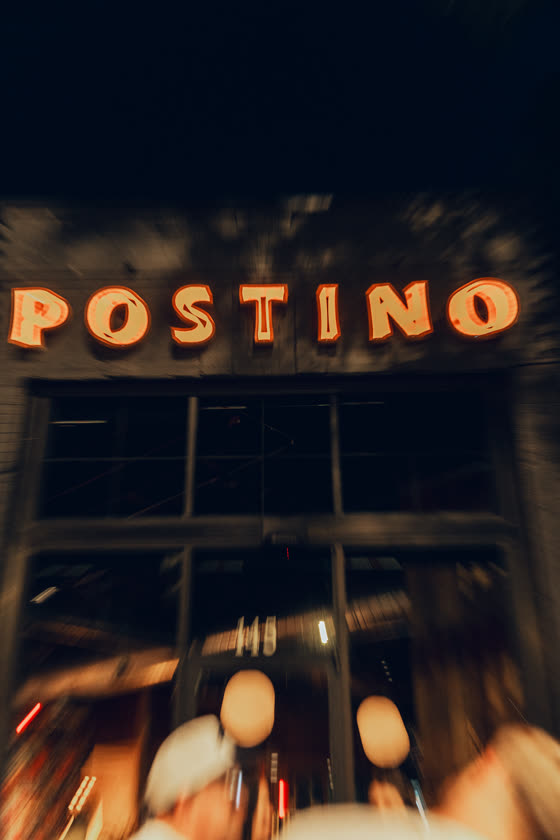 Restaurant sign glowing over the street at night