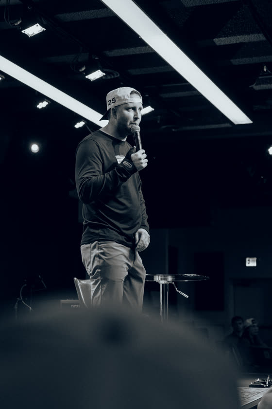 Speaker holding a microphone on stage at a local venue