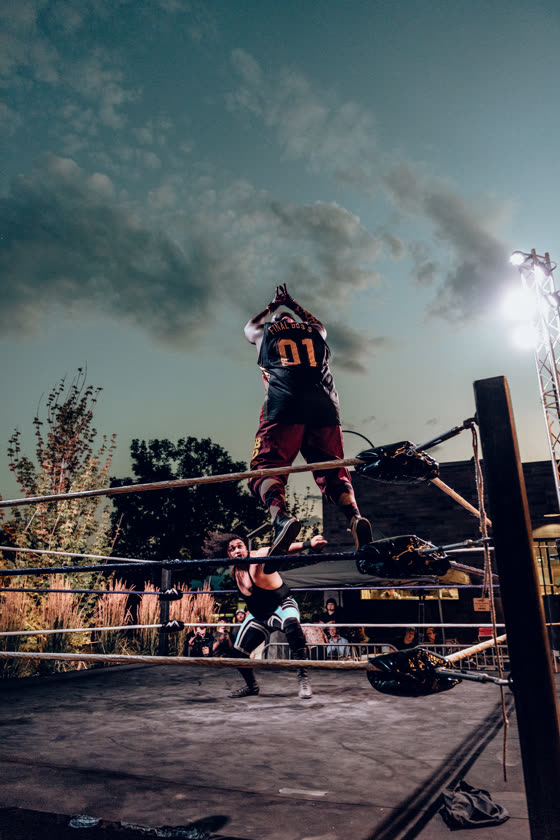 Wrestler working the crowd from the ropes at a local event